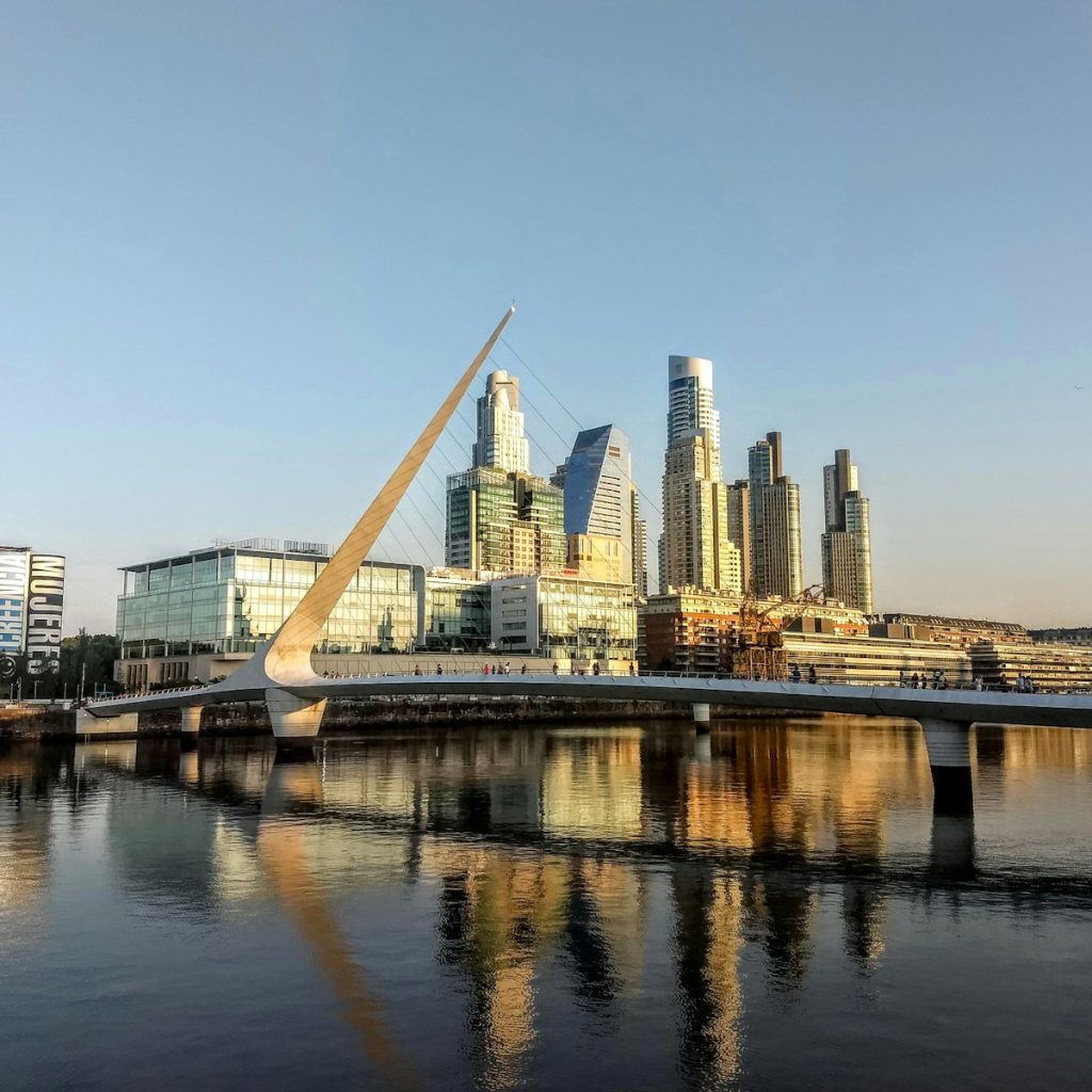 bridge over river near city buildings during daytime