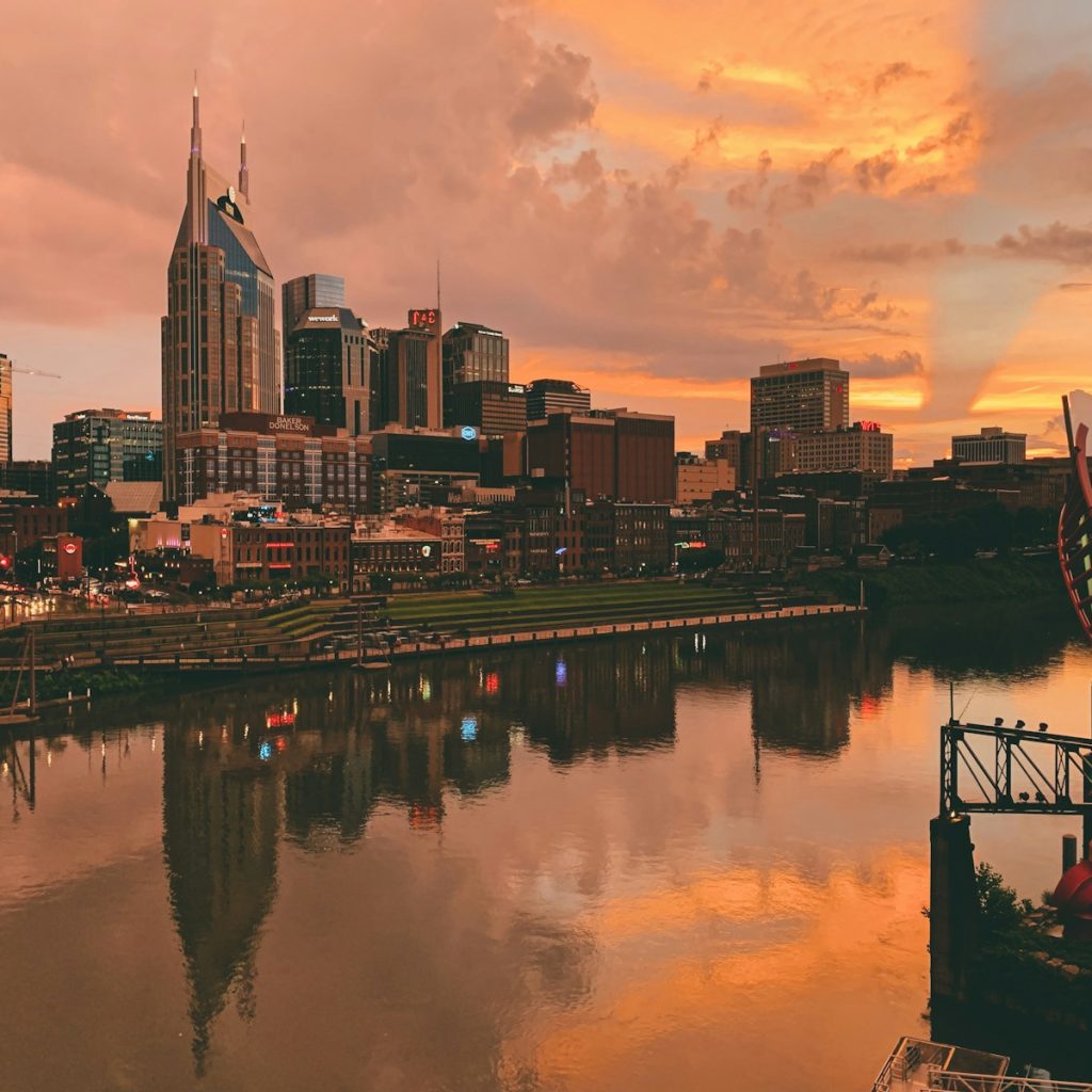 body of water near city buildings during sunset