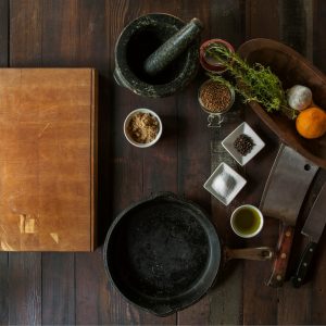 black mortar and pestle beside brown box in top view photography