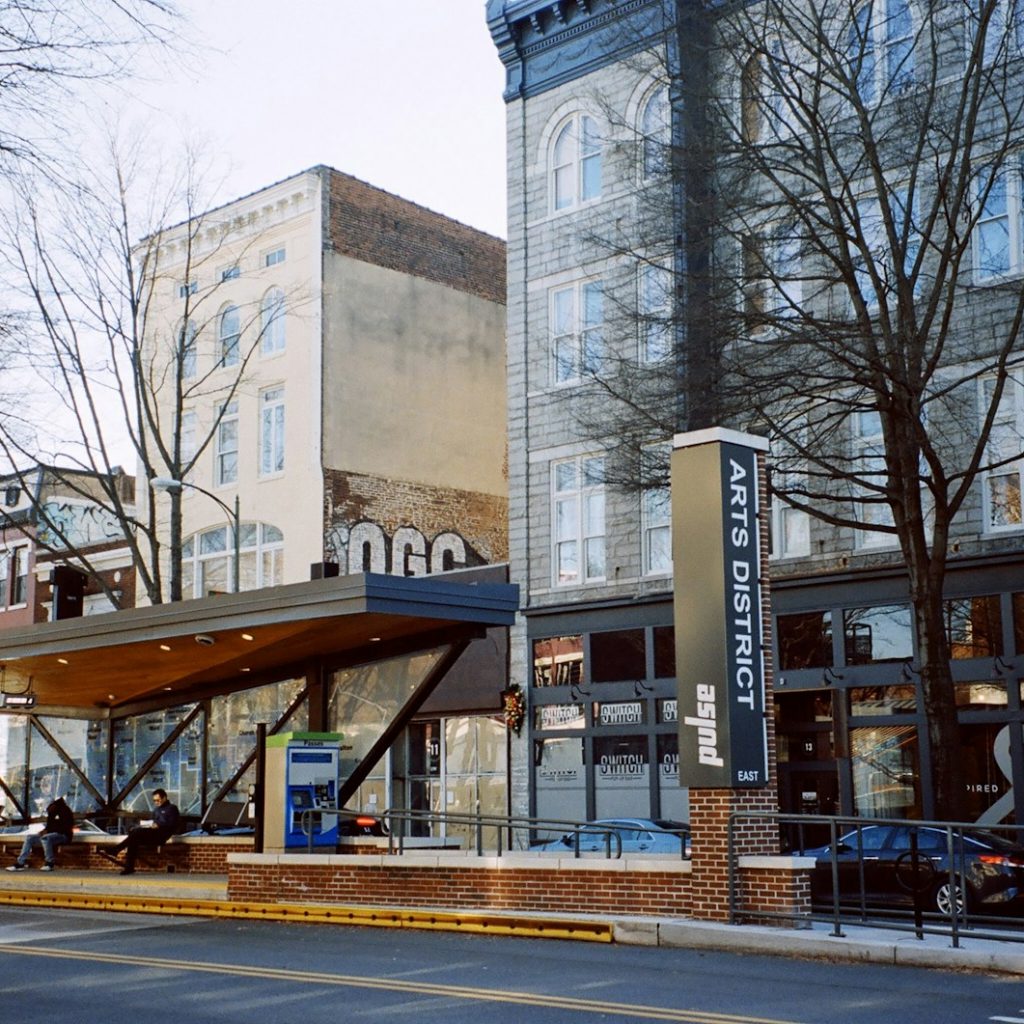 a city street with tall buildings and a bus stop
